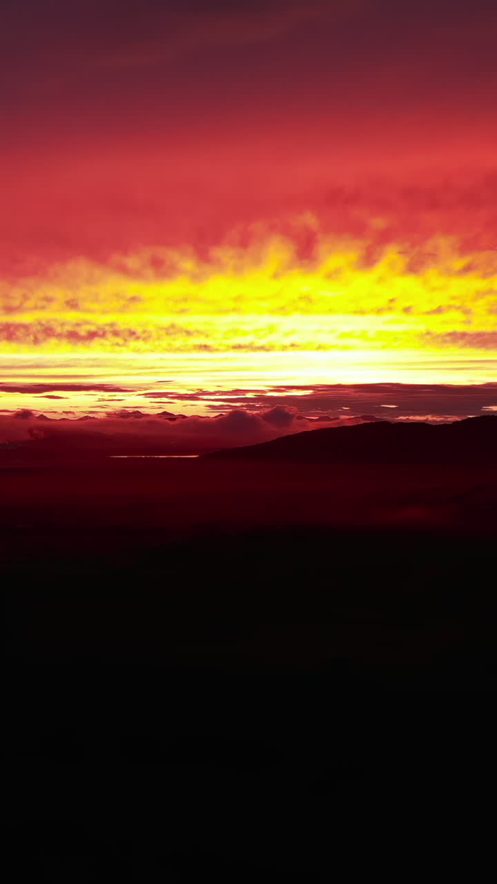 Dramatischer roter und gelber Himmel über Bergsilhouetten
