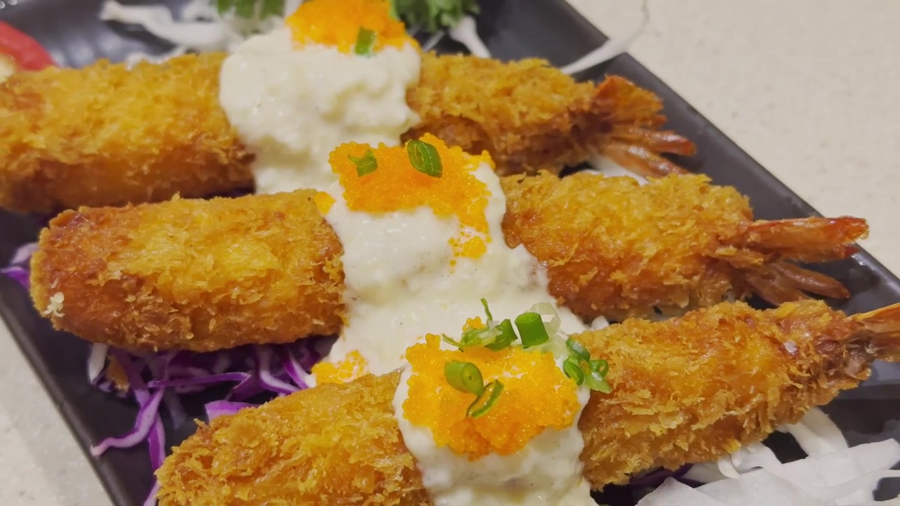 Video ravvicinato di tempura giapponese croccante splendidamente servita su un piatto tradizionale. Frutti di mare e verdure dorati in pastella presentati in un'autentica ambientazione culinaria