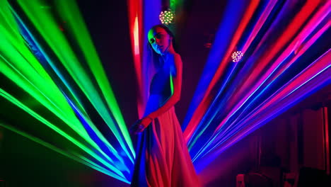 woman dancing amidst vibrant laser lights in a club