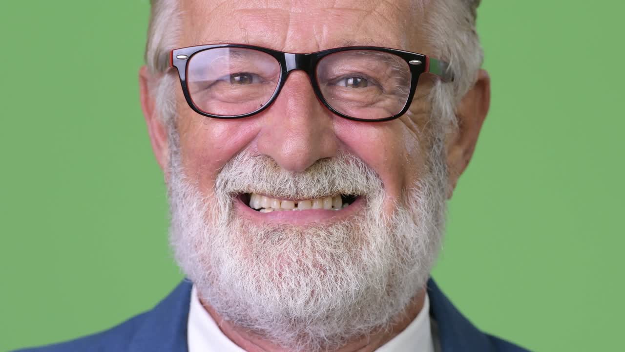 hombre de negocios barbudo y guapo contra un fondo verde.