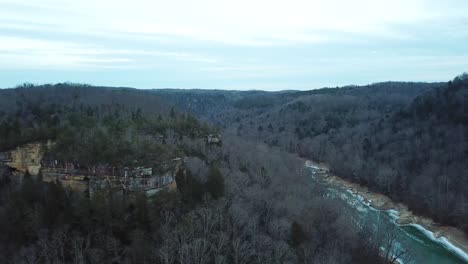 Aerial-Shot-of-Cliffs-Near-Icy-Mountain-River