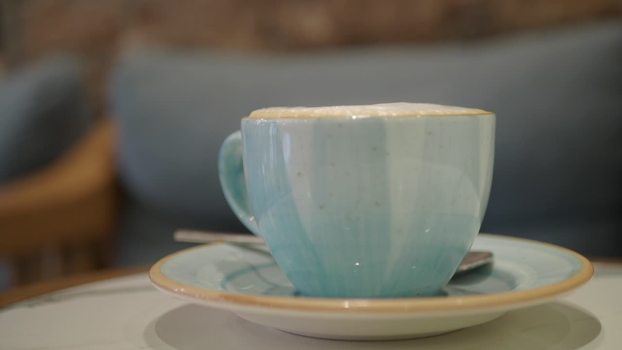 Primo piano di una tazza di caffè azzurra con schiuma