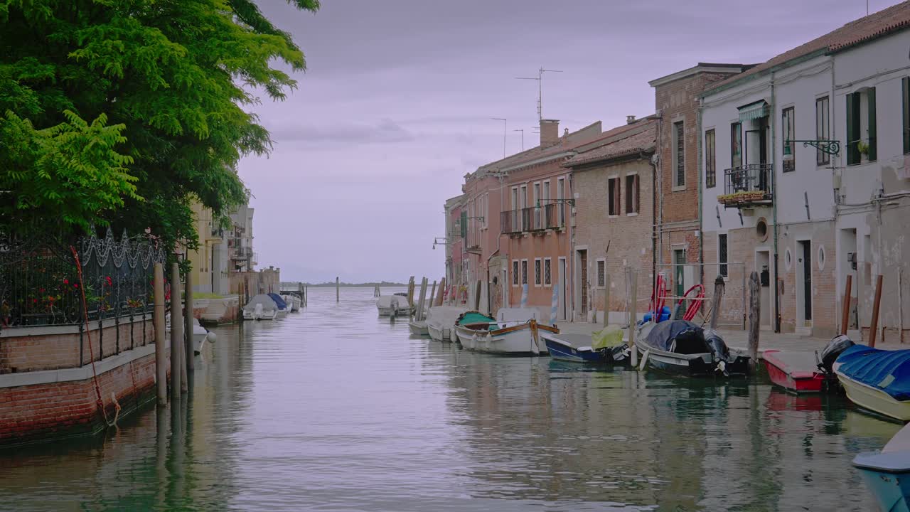 Residential canal area in Murano leads to Venetian lagoon on rainy day