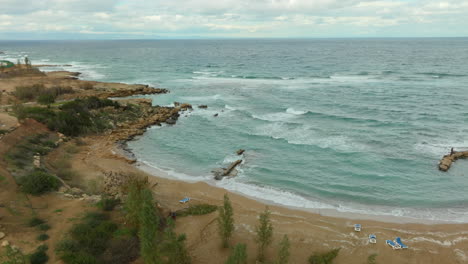 Die-Küstenlinie-Von-Kapparis-In-Paralimni-Bietet-Eine-Einzigartige-Mischung-Aus-Natürlicher-Und-Kultivierter-Landschaft,-Mit-Einem-Kleinen-Strand-Neben-Blühenden-Landwirtschaftlichen-Grundstücken