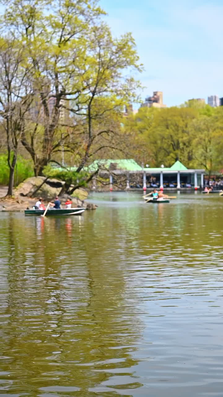Boating on a calm lake in New York. People enjoy a leisurely boat ride on a serene lake surrounded by trees in New York during springtime