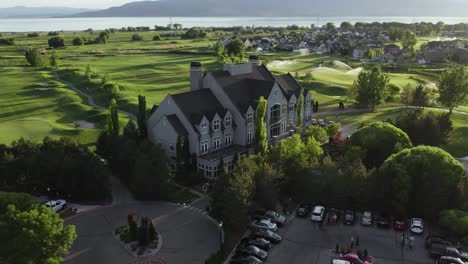 Orbit-above-sleepy-ridge-golf-course-clubhouse,-utah-lake-and-vineyard-behind