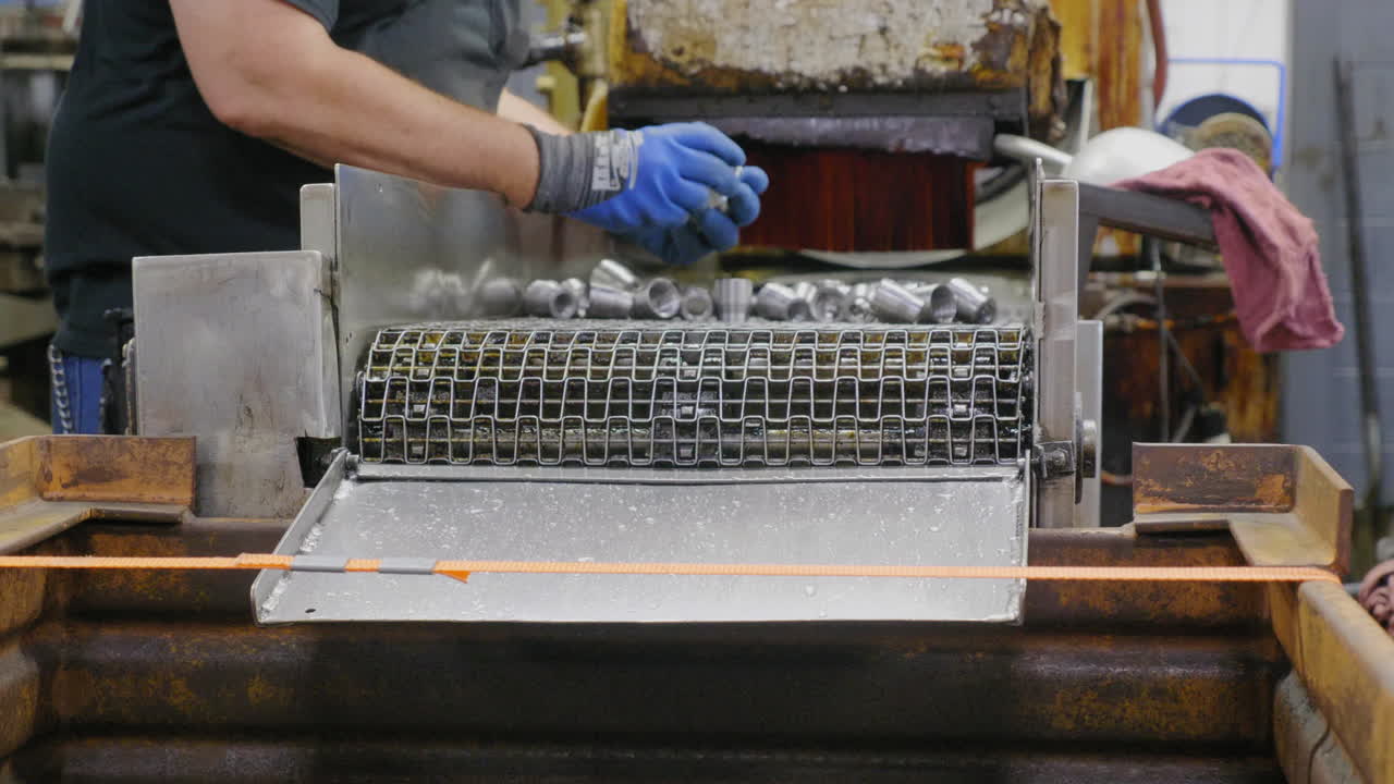 Factory workers inspecting a pushing fittings off a conveyor belt