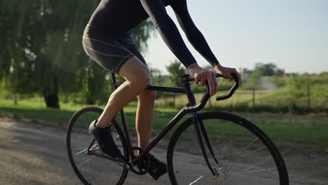 wheels of bicycle spinning while caucasian sportsman riding vehicle outdoors