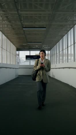 woman walking through an airport/train station tunnel