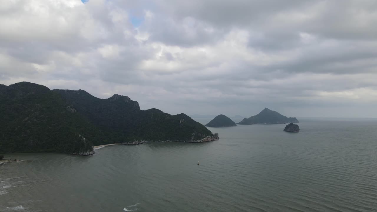 태국 프라추압키리칸(prachuap khiri khan), 삼로이욧 국립공원(sam roi yot national park)에서 흐린 날 동안 산과 섬, 파도가 해안으로 밀려드는 역방향 항공 영상