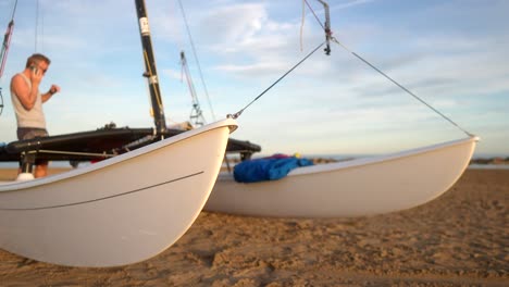 patines de catamarán vistos de cerca con un hombre hablando por teléfono en el fondo