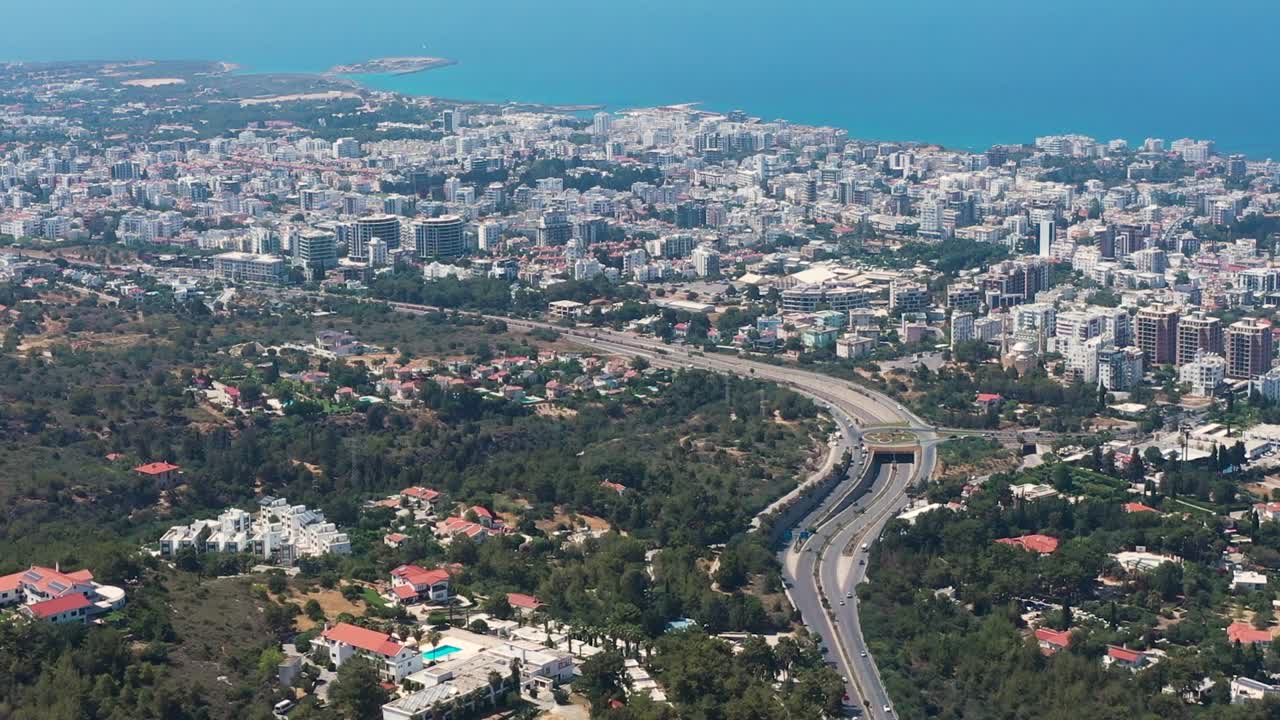 volando por encima de una autopista con vistas a la ciudad en expansión hacia el mediterráneo