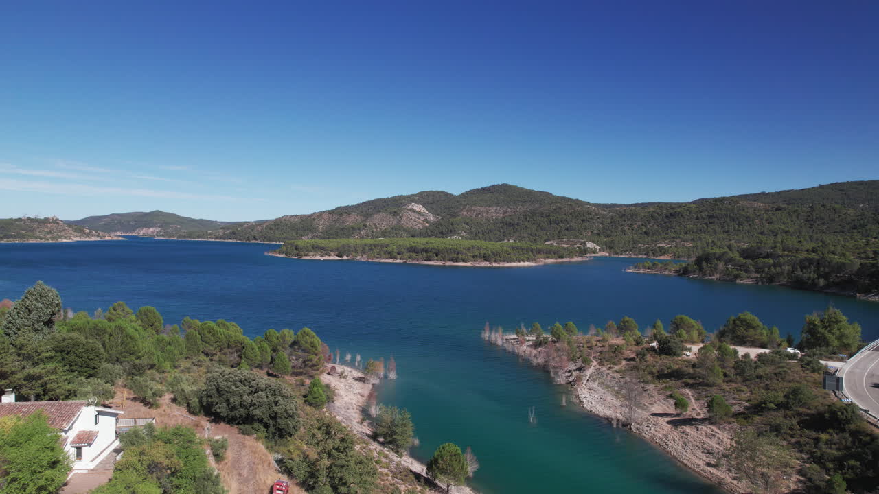 Embalse de Entrepeñas reservoir near Madrid, aerial shot moving backwards to reveal an abandoned gas station