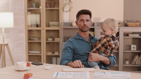 man videocalling with toddler in arms