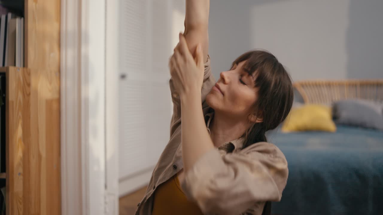 Woman stretching in her bedroom