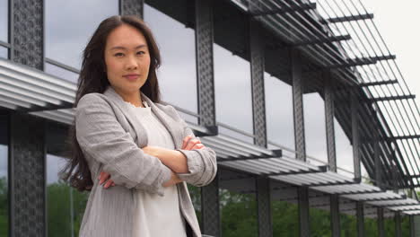 Portrait-Of-Serious-Businesswoman-Standing-Outside-Modern-Office-Building