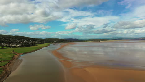 Aerial-shot-across-the-English-coastline-at-low-tide,-bright-sunny-day