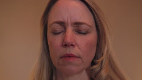 a woman wearing a necklace with her eyes closed