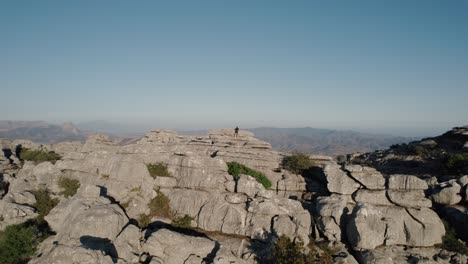 aerial drone rotating shot over eroded rocky mountain range in torcal de antequera, spain seen from above during evening time