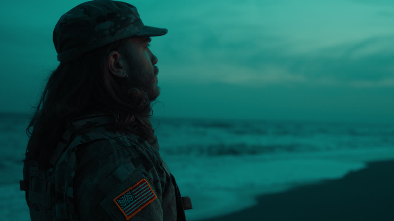 Silhuet af en soldat, der salutere på en strand om natten på US Memorial Day
