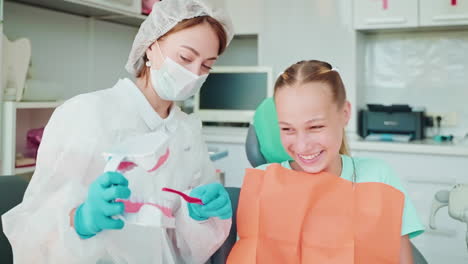 dentist teaching a child about teeth brushing