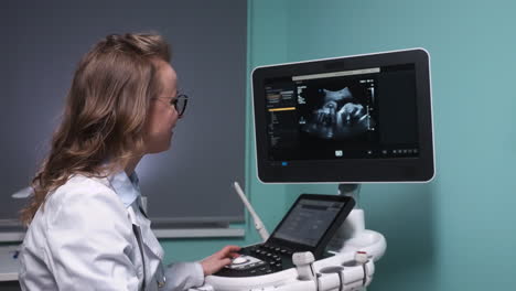 gynecologist observing a fetus on the ultrasound monitor while talking to her patient 1