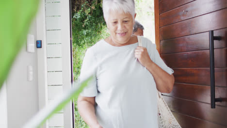 Happy-senior-diverse-couple-coming-home-with-groceries