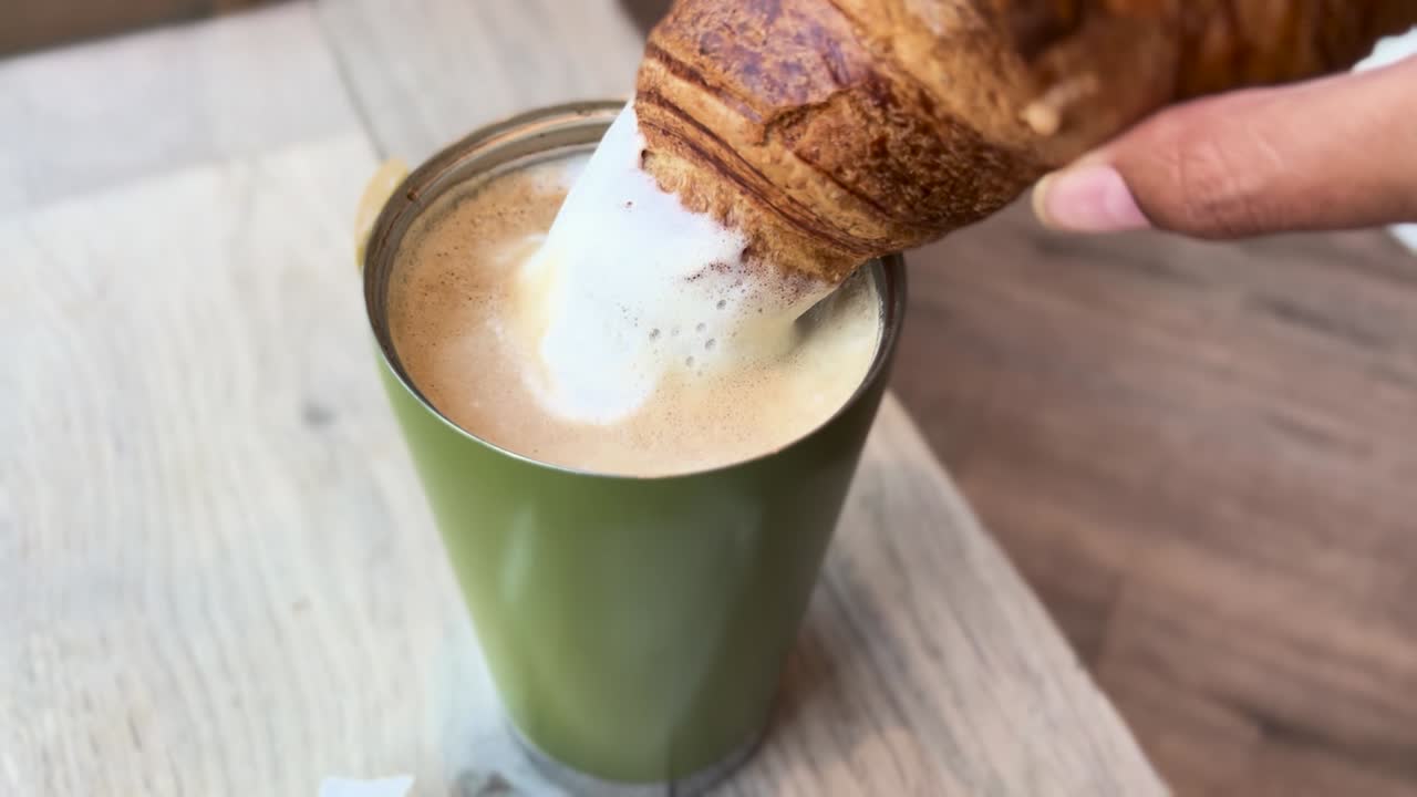 Breakfast Dipping Croissant into Coffee Latte