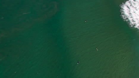 Aerial-top-down-view-of-surfers-waiting-for-the-right-wave-on-a-beautiful-clear-day-at-the-popular-seaway-lookout-The-Spit-Gold-Coast-QLD-Australia