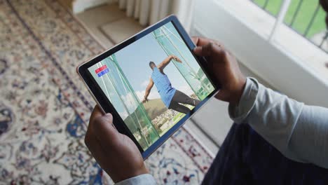 composite of man sitting at home watching athletics discus event on tablet