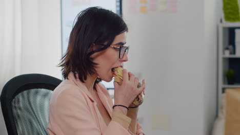 entrepreneur woman eating tasty sandwich having work break working in business company