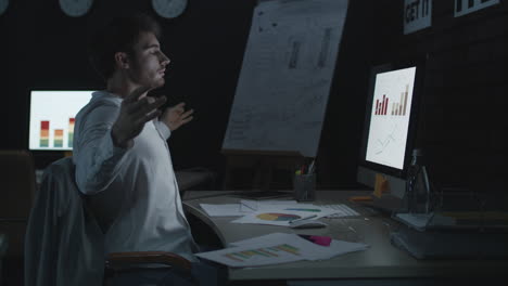 Stressed-businessman-meditating-in-yoga-pose-in-chair-in-night-office