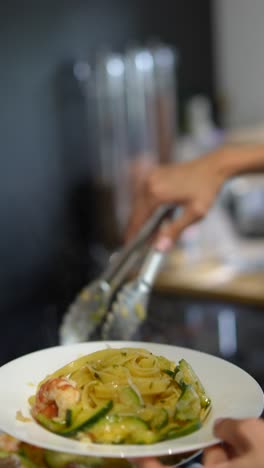 preparando un delicioso plato de pasta de camarón y calabacín