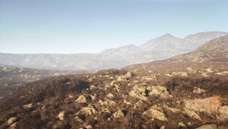 amazing shot of a rocky landscape partially covered with grass in a fog