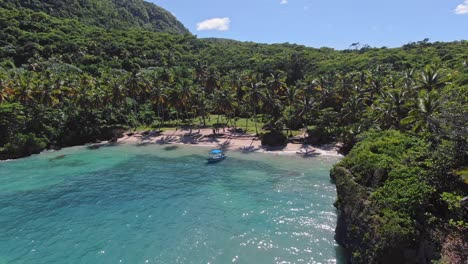 Paradise-bay,-lagoon-with-a-blue-boat-surrounded-by-dense-jungle,-hidden-spot