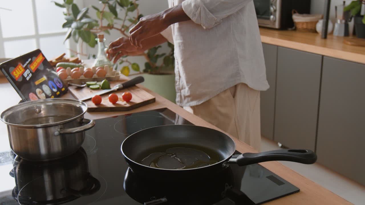 Man cooking eggs in the kitchen