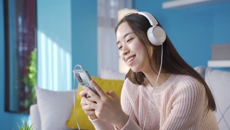 attractive cheerful asian woman listening to music.