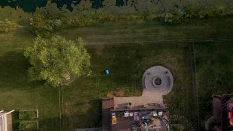 aerial view of a beautiful backyard with deck and fire pit