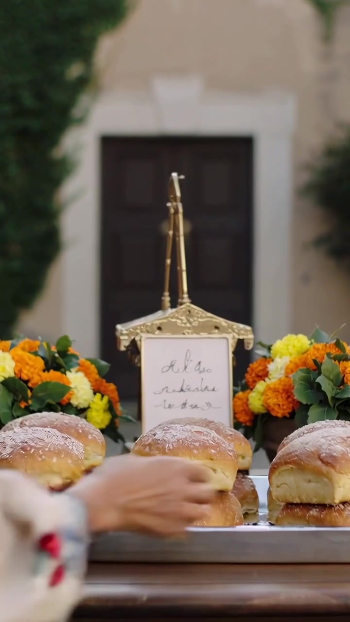 Vertical video: Approaching table, vendor in apron placing buns on metal tray for sale, copy space
