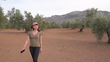 asian woman walking near olive trees