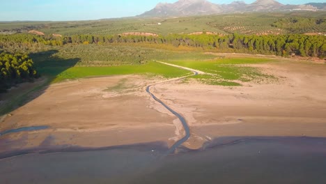 Vista-Aérea-De-Un-Río-Que-Desemboca-En-Un-Lago-En-Una-Zona-De-Sequía-En-Andalucía,-España