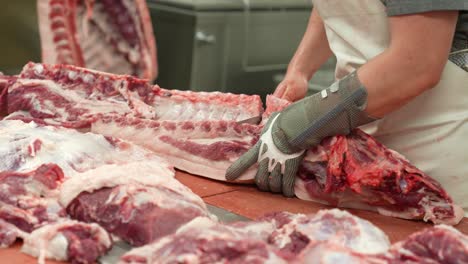 abbatoir slaughterhouse operative knife cutting on rib beef carcass