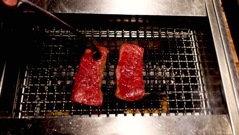 steaks cooking on a grill, turning from raw to done.