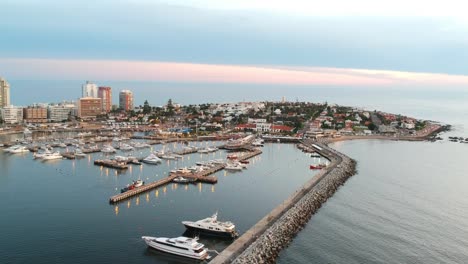 drone shot of yachts and hotels in punta del este during the sunset