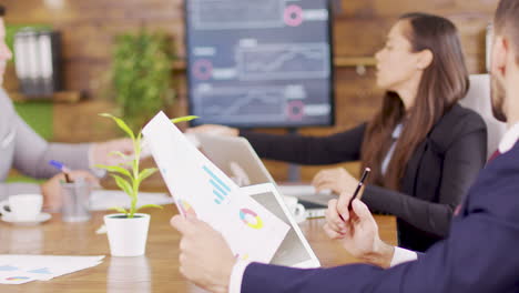 businessman in suit analysing charts on his tablet