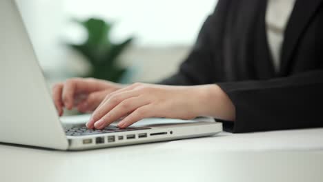 close up hand woman texting on keyboard laptop work sitting working in office.