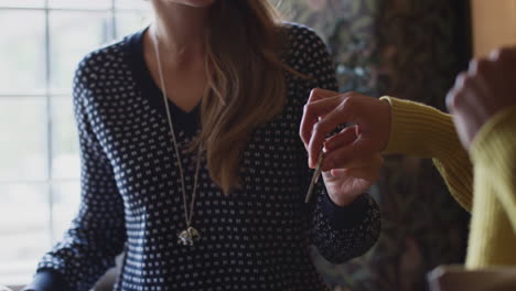 Receptionist-Handing-Guest-Couple-Key-As-They-Check-Into-Hotel