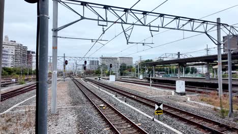 railway lines with overhead wires extend through a city landscape, showcasing modern urban life.