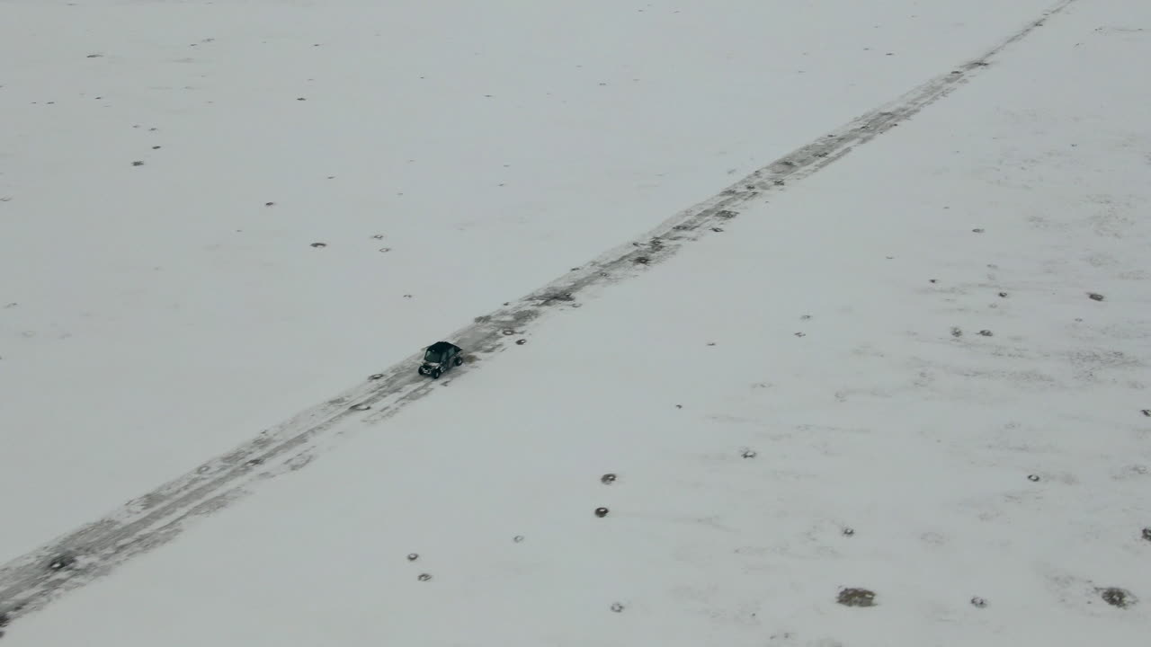 utv가 나란히 눈 덮인 도로를 따라 아래를 내려다보는 공중 샷, 4k