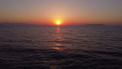 golden sunset above the sea, aerial drone flight forward to the sun